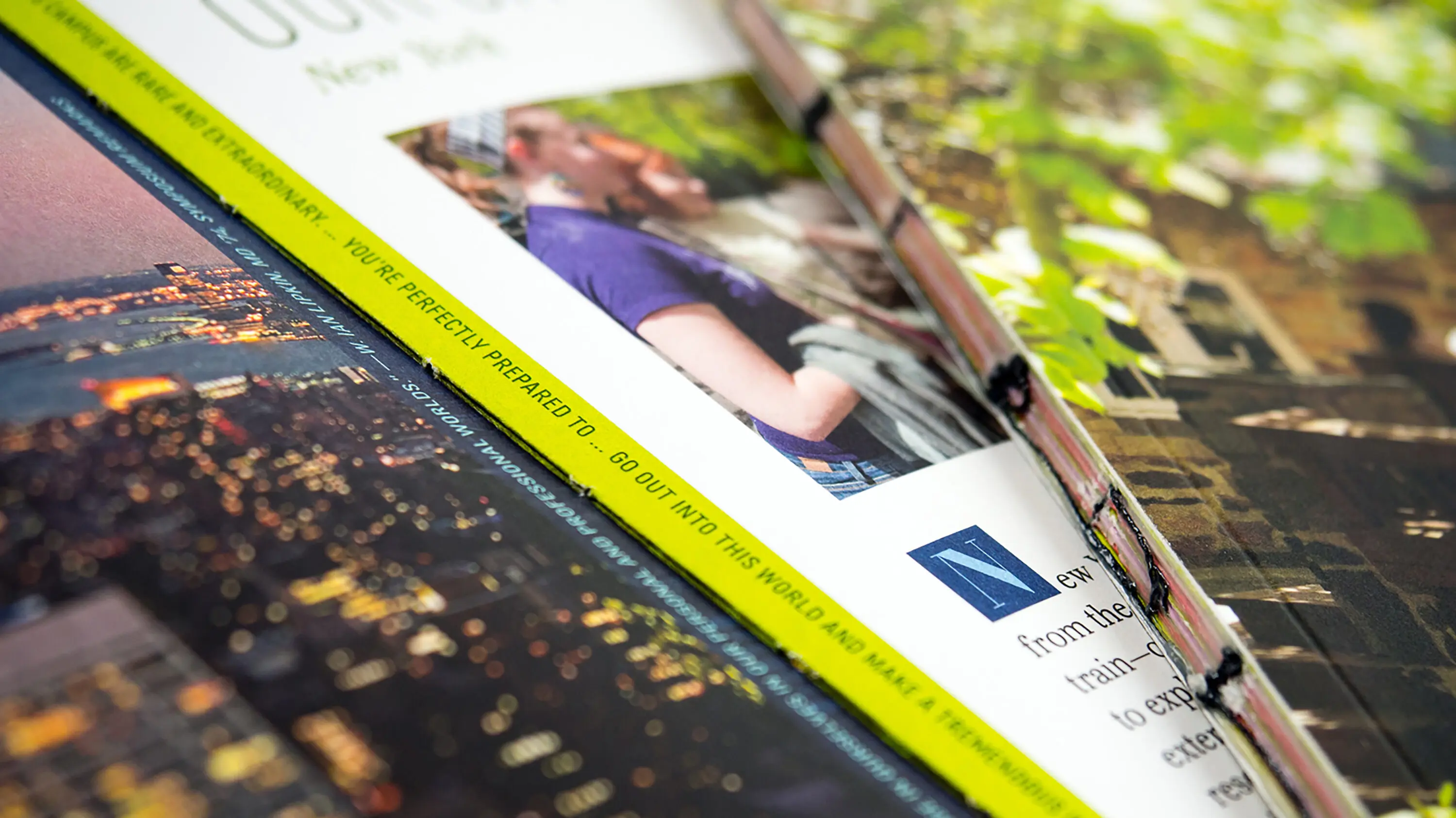 Image of details found on the student viewbook: the binding on the spine of the book, as well as a closeup look at the spread's typography and imagery of a city skyline at night.